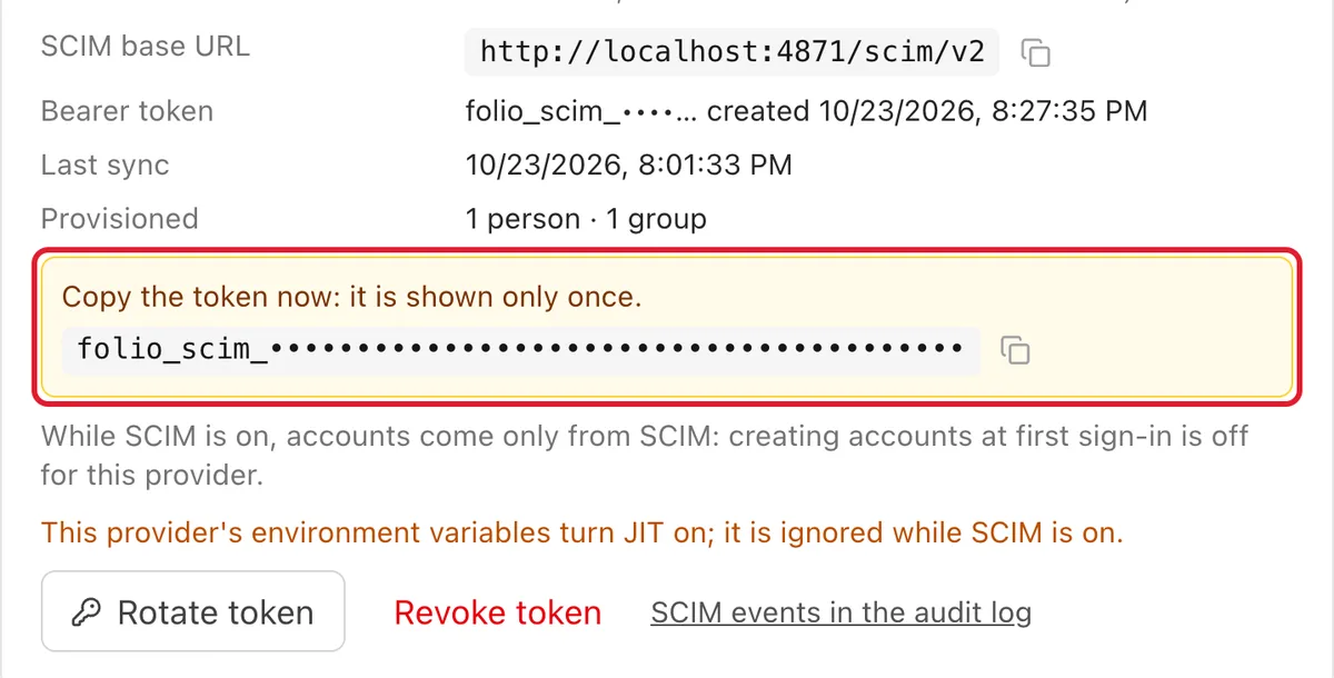 The SCIM provisioning panel of a Folio sign-in provider: the base URL, a bearer token shown once with a copy button, the time of the last sync, one provisioned person and one group, and the buttons Rotate token and Revoke token
